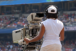 A camerawoman covers a tennis match