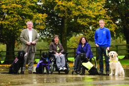 Group of four people, each with an assistance dog