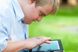 A man with Downs Syndrome searches for information on an iPad