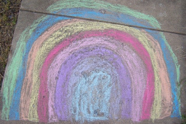 A rainbow drawn in chalk on a pavement