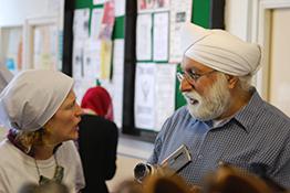 A man and woman talking in a community centre