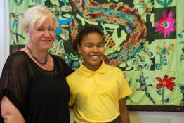 Teacher and transgender student standing in front of colourful mural